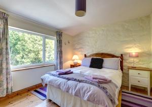a bedroom with a large bed and a window at Woodbine Cottage in Saint Hilary