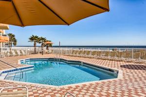 uma piscina com guarda-sol e a praia em The Enclave #507 em Orange Beach