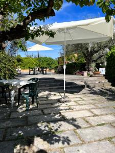 a patio with a table and an umbrella at Le sorelle gemelle B&B in Teramo