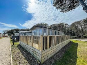ein Haus mit einem Zaun davor in der Unterkunft Stunning Caravan With Wifi At Azure Seas Nearby The Beautiful Beach Ref 32057az in Lowestoft