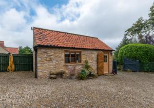 ein kleines Steinhaus mit rotem Dach in der Unterkunft The Hayloft in Nawton