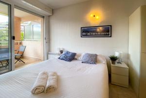 a bedroom with a white bed with two pairs of slippers at Les Terrasses 2Pers Parking WiFi in Roquebrune-Cap-Martin