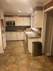 a large kitchen with white cabinets and a trash can at Elegant 6 Bedroom Home in Heart of Memphis in Memphis