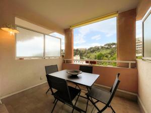 a dining room with a table and chairs and a window at Les Terrasses 2Pers Parking WiFi in Roquebrune-Cap-Martin