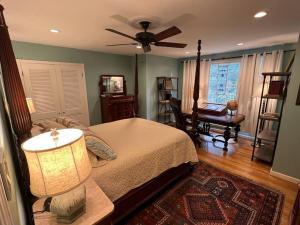 a bedroom with a bed with a ceiling fan and a desk at Elegant 6 Bedroom Home in Heart of Memphis in Memphis