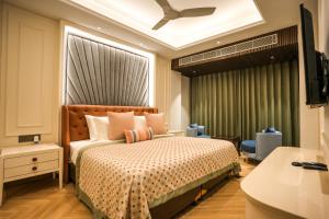 a hotel room with a bed and a television at Atithi House in Greater Noida