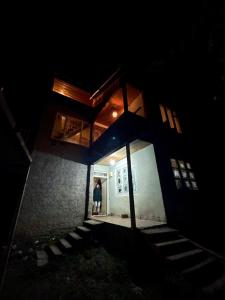 a person standing in the doorway of a house at night at Guesthouse in Utsera in Utsera