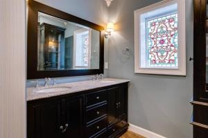 a bathroom with a sink and a mirror and a window at Elegant 6 Bedroom Home in Heart of Memphis in Memphis