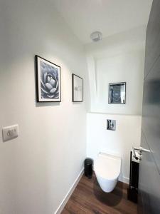 La salle de bains est pourvue de toilettes et de photos murales. dans l'établissement Belle maison rénovée à la plage, à Fouesnant