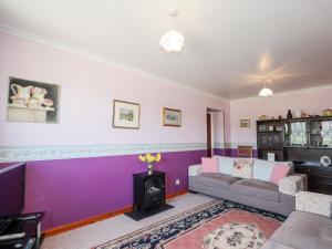 a living room with purple walls and a couch at Balnabodach in Inverness