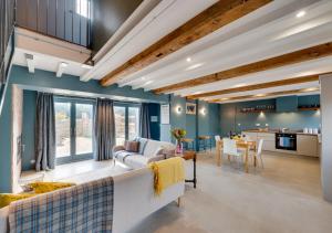 a living room with blue walls and wooden ceilings at The Granary at The Foldyard in Holme upon Spalding Moor