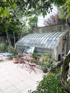 a greenhouse with a table and chairs in a garden at SalutBB Chambre d'hote in Carcassonne