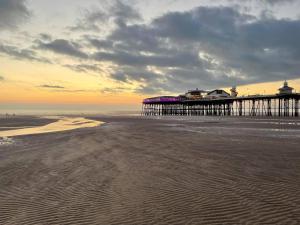 Blick auf einen Pier am Strand bei Sonnenuntergang in der Unterkunft Magenta Melodies, 5 Bedroom House in Blackpool