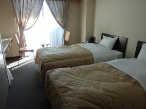 um quarto de hotel com duas camas e uma janela em Sawa Hotel em Fujikawaguchiko