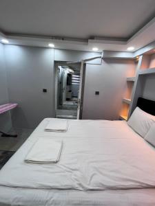 a large white bed in a room with a mirror at LİFE APART- basement in Istanbul