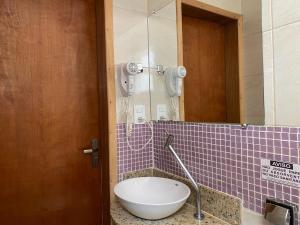 a bathroom with a toilet in a purple tiled wall at Hotel do Reinildo II in Cachoeira Paulista