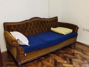 a brown couch with two pillows on top of it at Vintage apartment in the center of Novi Sad in Novi Sad