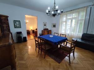 a dining room with a blue table and chairs at Vintage apartment in the center of Novi Sad in Novi Sad