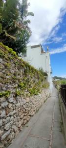 a stone wall next to a sidewalk next to a street at Capri Suite Dreams in Capri