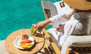 een vrouw aan een tafel met een bord fruit bij Pestana Rio Atlantica in Rio de Janeiro