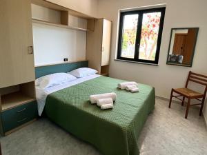 een slaapkamer met een bed met twee handdoeken erop bij Case Vacanza Calabria Ionica in Cropani