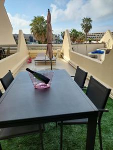 a table with a bottle of wine on a roof at Studio Heliopolis Naturiste in Cap d'Agde
