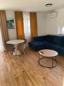 - un salon avec un canapé bleu et une table dans l'établissement APPARTMENTS SARA, à Jadranovo