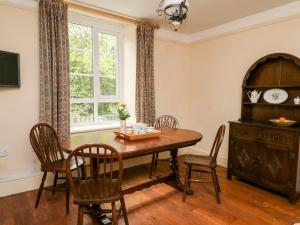 een eetkamer met een tafel en stoelen en een raam bij Myrtle Villa in Knighton