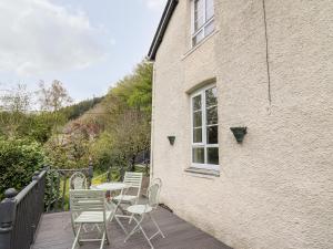 a patio with a table and chairs on a deck at Myrtle Villa in Knighton