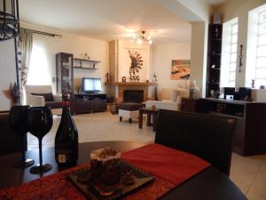 Sala de estar con sofá y mesa con botella de vino en Psaromoura Residence, en Agia Pelagia