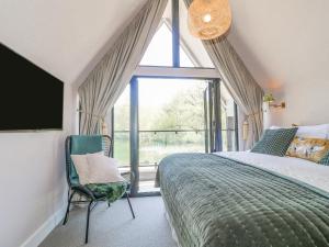 a bedroom with a bed and a large window at Lakeside Lodge in Wolverhampton