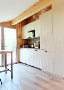 a kitchen with white cabinets and a table at Maison de vacances 2 chambres plages lac à 600m proche Dune du Pilat Océan dans propriété privée in Sanguinet