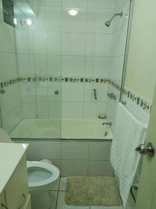 a white bathroom with a shower and a toilet at Miraflores View in Lima