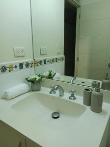 La salle de bains est pourvue d'un lavabo blanc et d'un miroir. dans l'établissement Miraflores View, à Lima