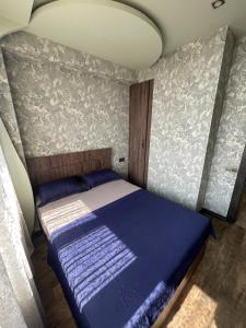 a small bedroom with a blue bed in it at Avchieva's apartment on Orbeli Brothers Street in Yerevan