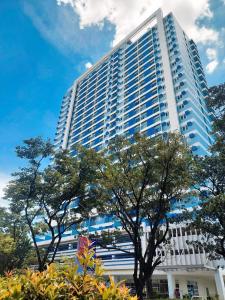 un edificio alto con árboles delante de él en Prime Studio at The Loop Tower en Cagayán de Oro