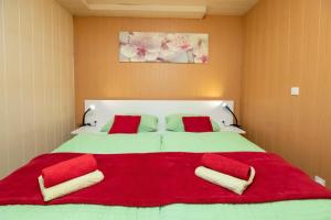 a large bed with red pillows and a red blanket at Studio Ara in Bohinj