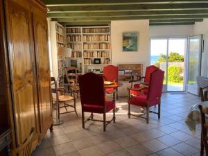 een woonkamer met rode stoelen en een tafel bij Maison face l’Ocean in Plozévet