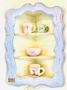 una mensola in legno con tre tazze di caffè sopra di Casa Angiolina - Holidays a Morcote