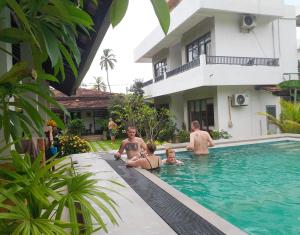 eine Gruppe von Personen im Schwimmbad eines Hauses in der Unterkunft Green Wood Villa Negombo in Negombo