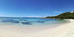 una spiaggia con un gruppo di persone in acqua di Boheme 4 personnes ( 2 chambres ) a Saint-François Altre 100 foto