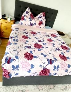 1 cama con colcha floral y almohadas en Kleine Wohnung im Zentrum Bern nähe Marzili, en Berna