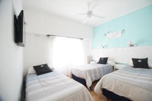 um quarto com 2 camas e uma televisão de ecrã plano em Dodo Suites em Mar del Plata