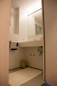 uma pequena cozinha com armários brancos e um lavatório em Bosruck Chalet em Misselsdorf