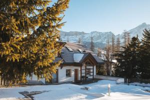 Una casa en la nieve con montañas al fondo en Casa Zilli, en La Villa