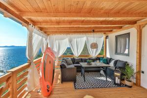 eine Terrasse mit einem Sofa und einem Tisch mit einem Surfbrett in der Unterkunft Serenity Mobile House in Drage