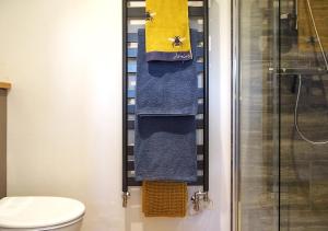 a bathroom with blue and yellow towels and a shower at The Bothy in Carlton