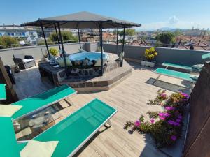 een patio met tafels en een parasol op een dak bij Hotel Memory in Rimini