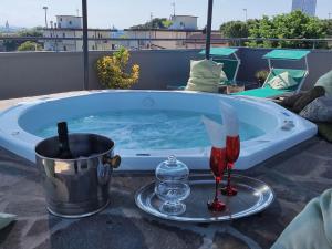 een hot tub met een glas wijn en wijnglazen bij Hotel Memory in Rimini