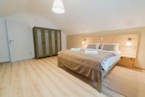 a bedroom with a large bed with a wooden wall at Casa Verde and Casa Blue in Janja Gora +25 photos